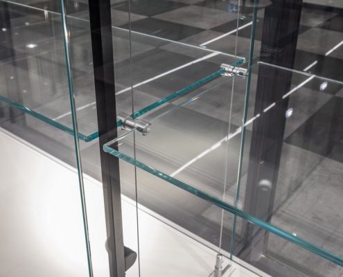 Lasivitrinii hyllyn lähikuva vaijerikiinnitys