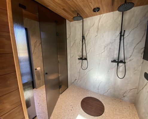 Artesaanilasinen kylpyhuoneen raitalasiseinä-pronssi raita-mustat viimeistelyt-mittatilaus-villa_satakielin-asuntomessut 2025 oulu