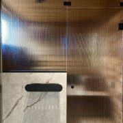 Artesaanilasinen saunan lasitus-pronssi raita-mustat viimeistelyt-mittatilaus-villa_satakielin-asuntomessut 2025 oulu-kuvaaja charlotta taskinen