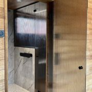 Artesaaniraitalasiovi-pronssi raita-mustat viimeistelyt-mittatilaus-villa_satakielin-asuntomessut 2025 oulu-kuvaaja charlotta taskinen