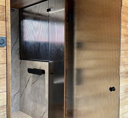 Artesaaniraitalasiovi-pronssi raita-mustat viimeistelyt-mittatilaus-villa_satakielin-asuntomessut 2025 oulu-kuvaaja charlotta taskinen